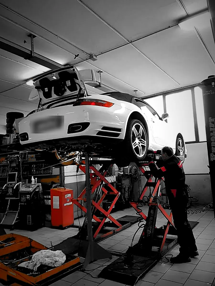 Il titolare al lavoro sotto una Porsche 911 Turbo Cabriolet sul ponte